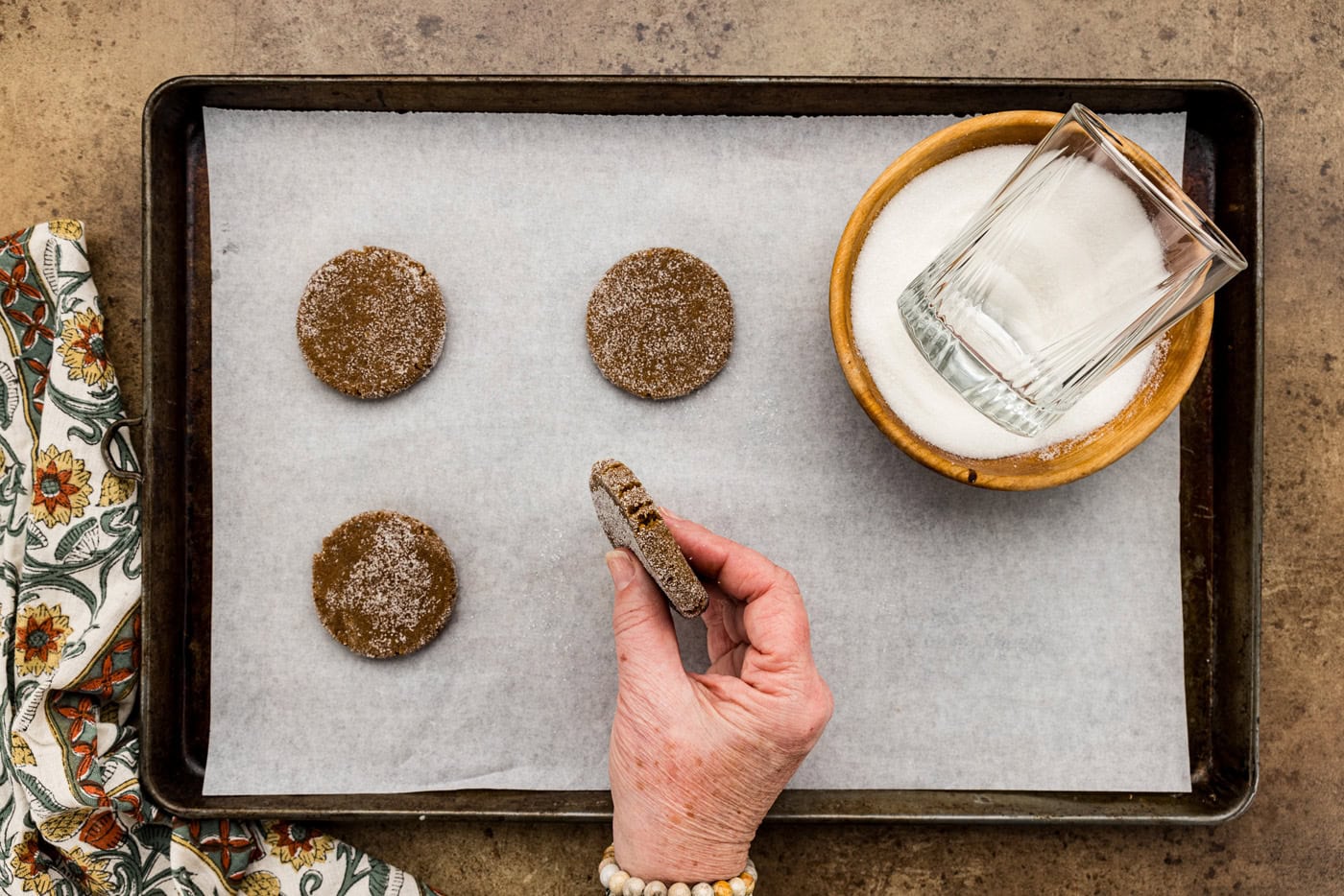 hand holding flattened cookie dough to show how thick it should be