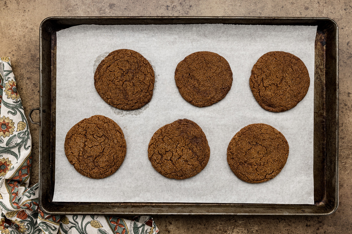 baked molasses spice cookies on a baking sheet
