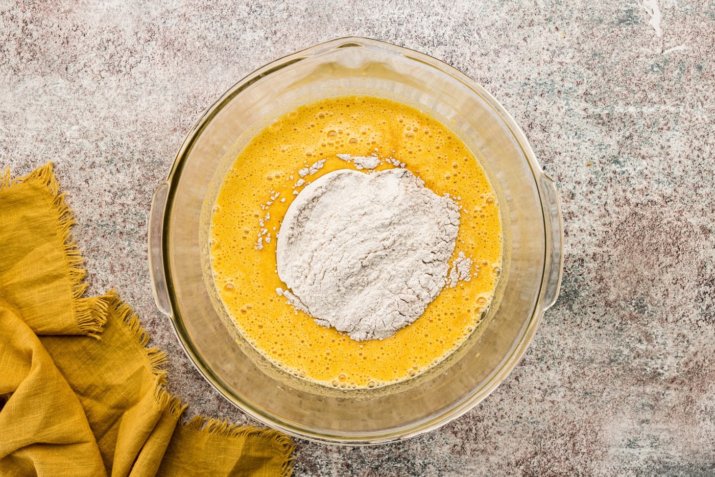 Flour mixture added to pumpkin batter in a bowl