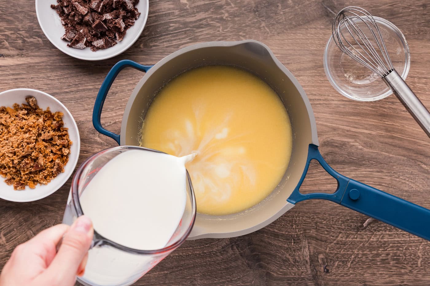 Pouring milk into masa harina and water mixture in a saucepan