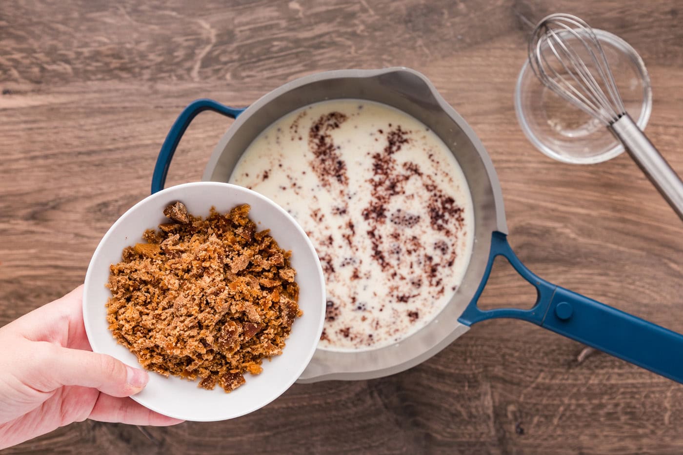 Adding piloncillo to saucepan with milk, Mexican chocolate, and masa harina mixture