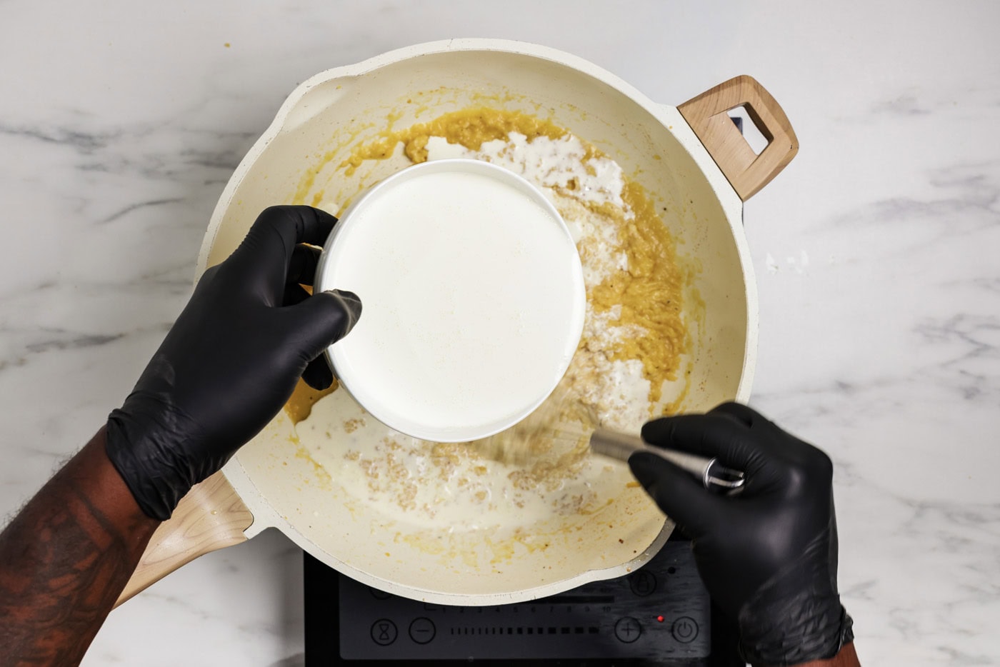 heavy cream added to skillet with a whisk