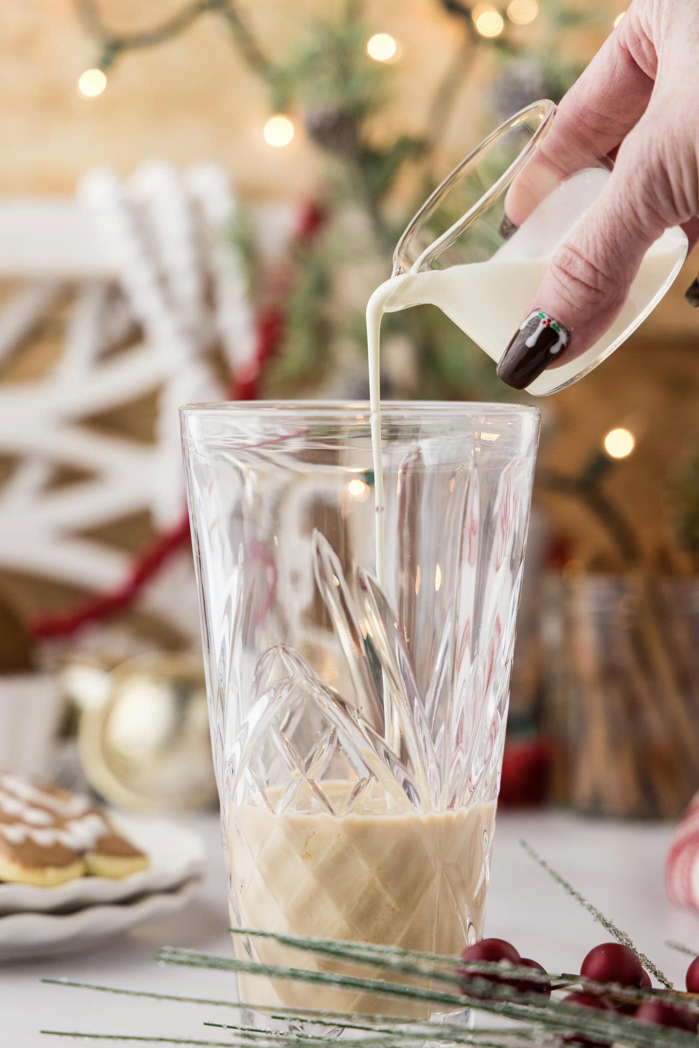 pouring heavy cream into cocktail shaker glass 