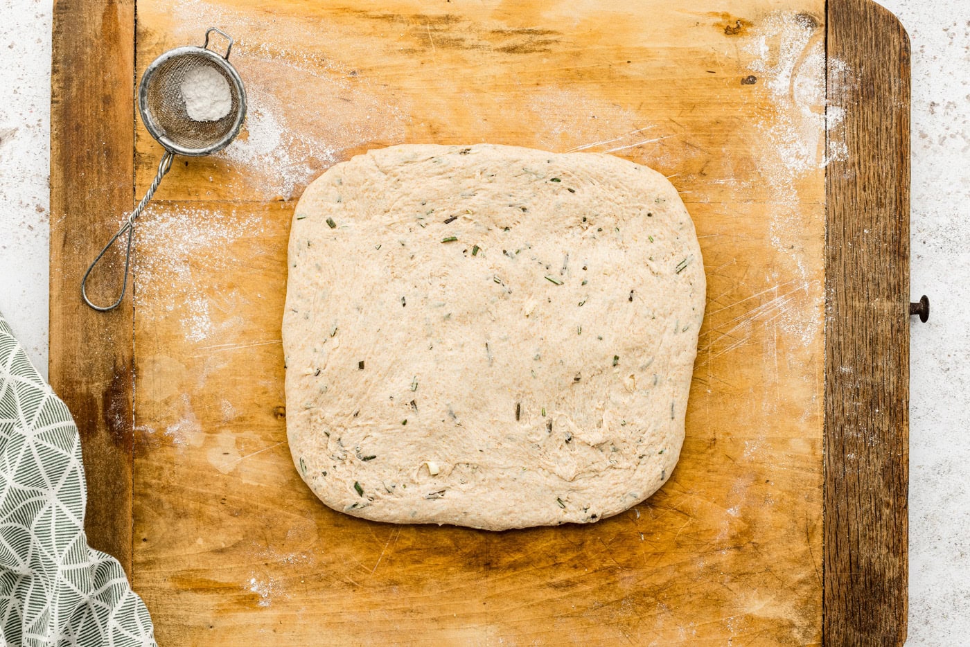 bread dough shaped into a square on a cutting board