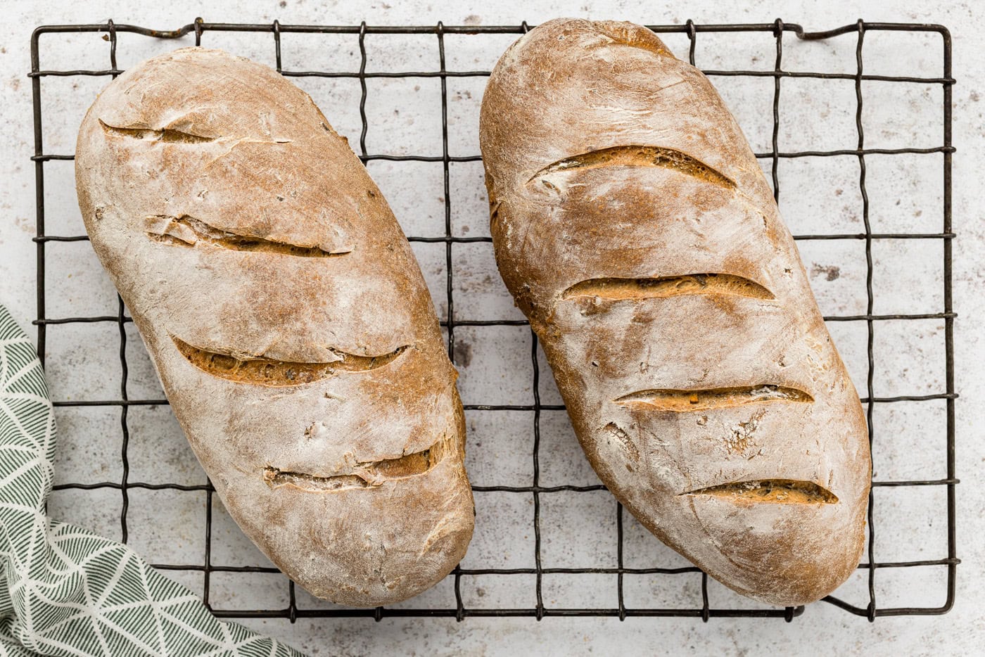 Baked rustic rosemary garlic bread loaves on a wire cooling rack