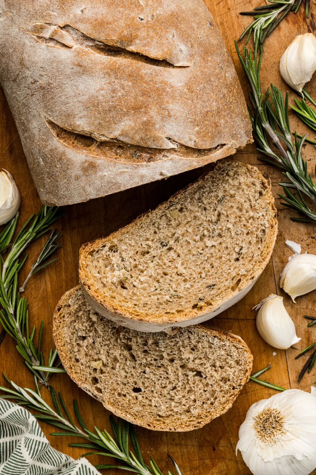 Two slices of Rosemary Garlic Bread resting on a wooden cutting board