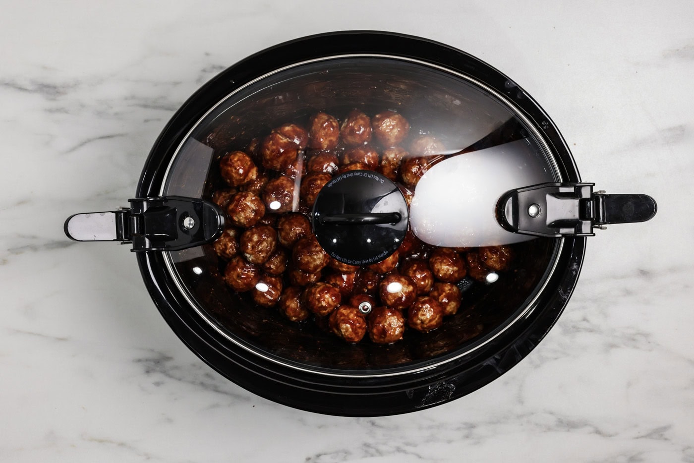 Barbecue meatballs in a crockpot covered with a lid
