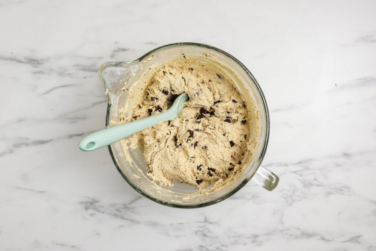 Chopped chocolate folded into cookie dough with a rubber spatula