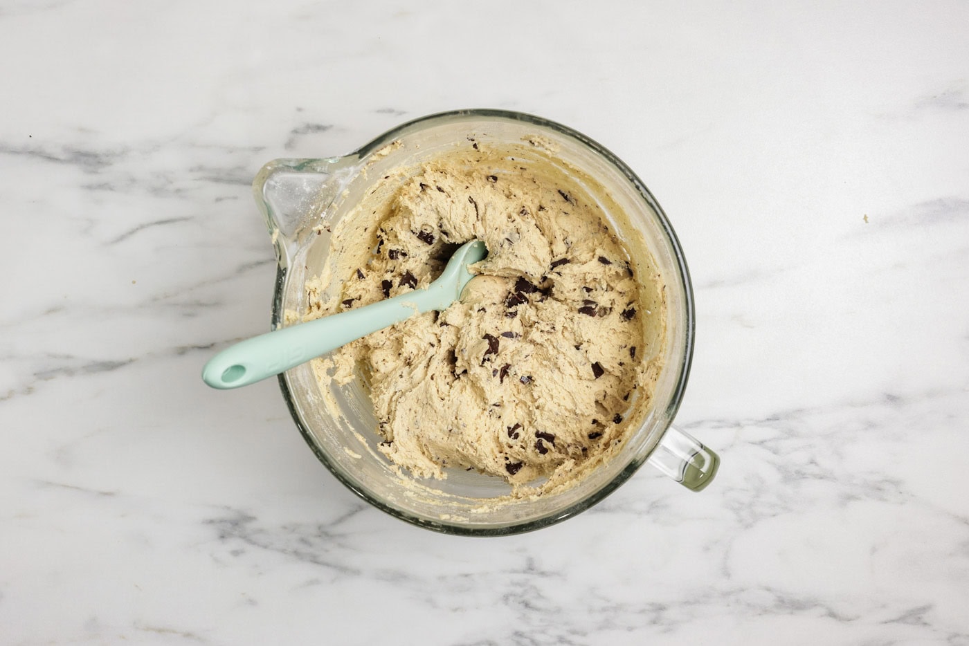 Chopped chocolate folded into cookie dough with a rubber spatula