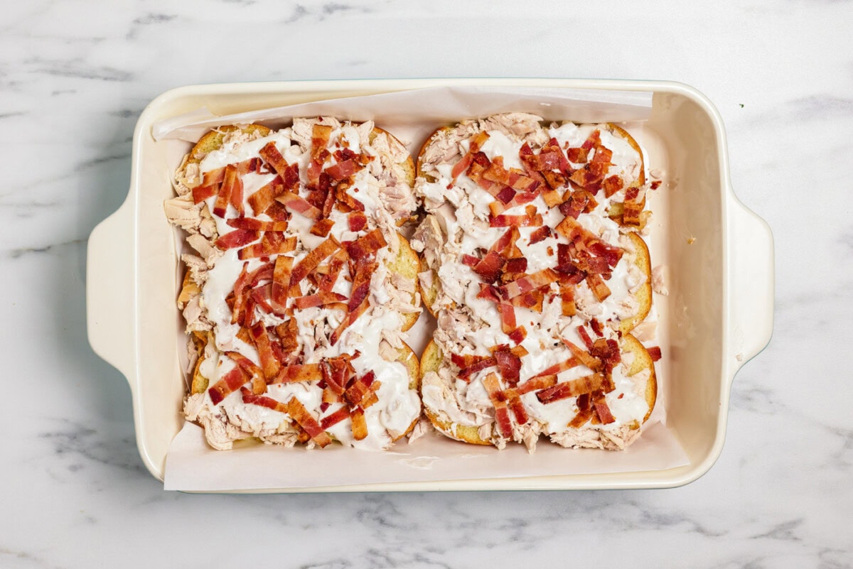 Chopped bacon sprinkled on top of ranch and chicken over slider buns