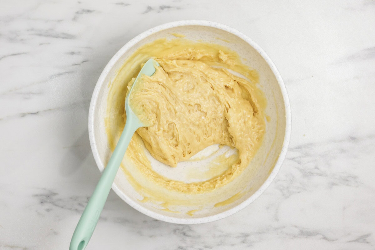 Rubber spatula in a bowl with vanilla muffin batter