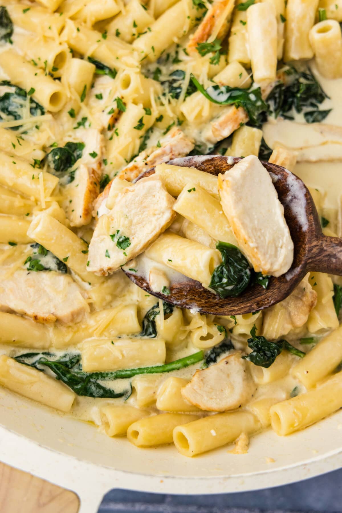 Close up photo of a spoonful of Garlic Chicken Pasta in a skillet