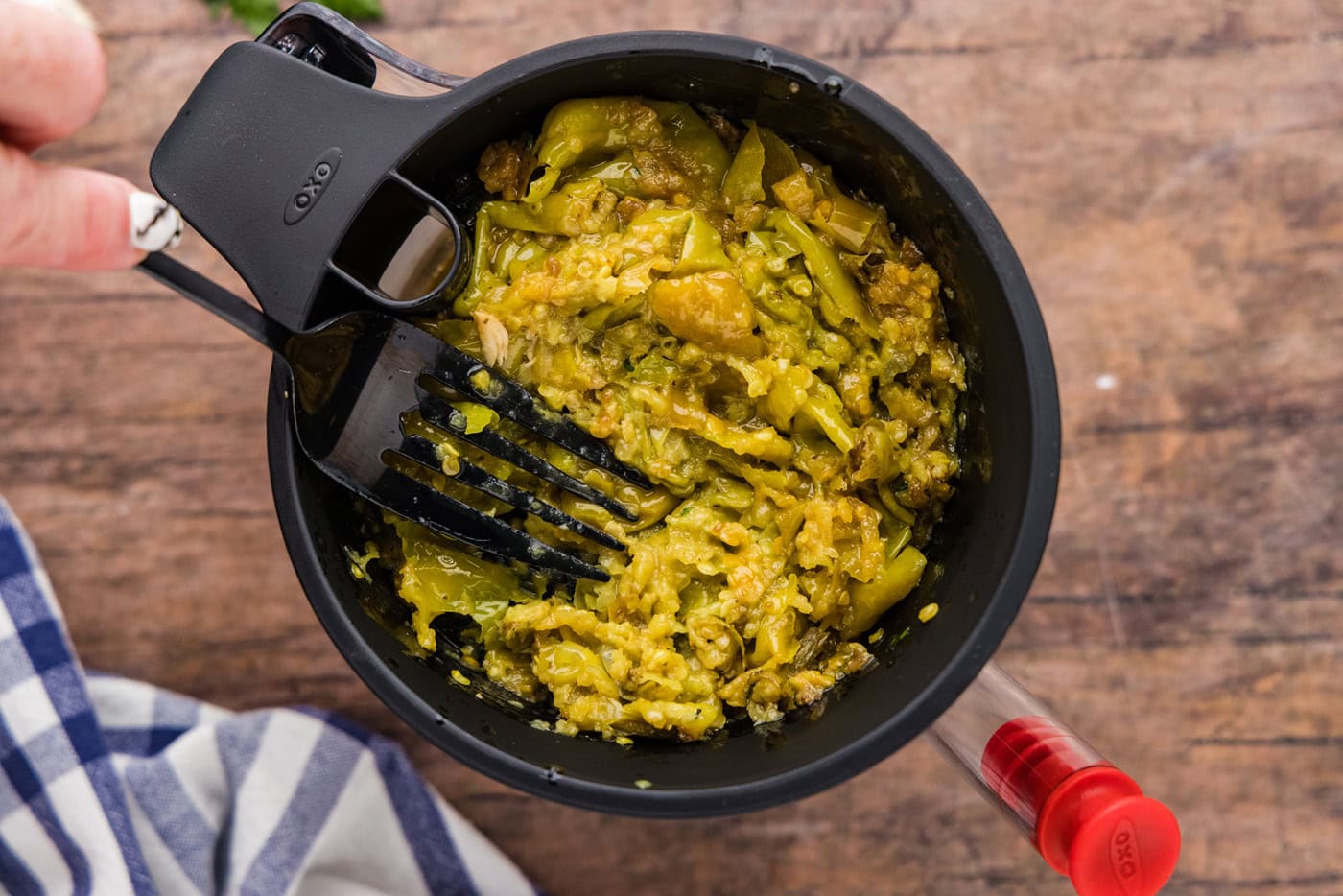 smashed pepperoncinis in the lid of a fat separator
