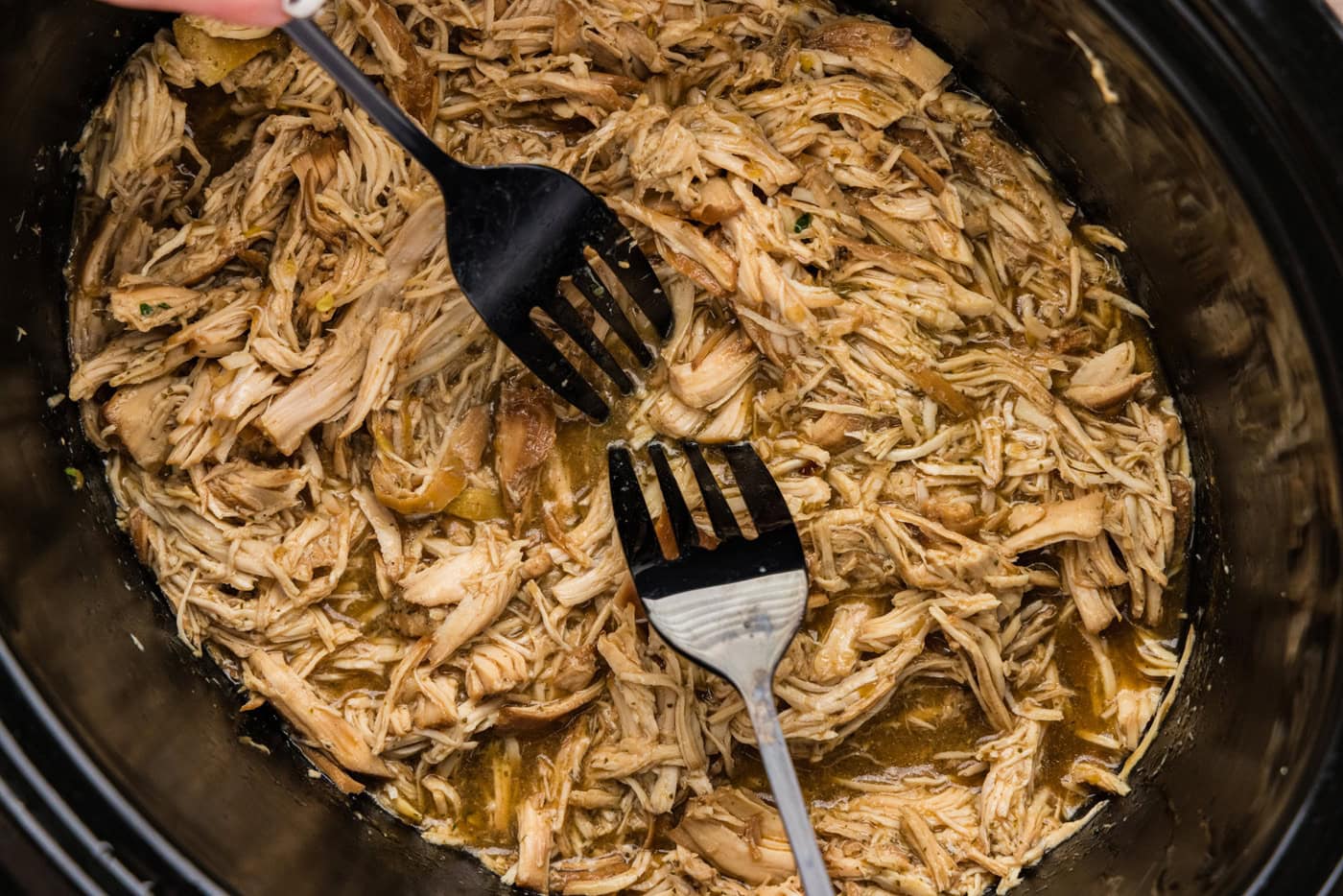 Shredding chicken in a crockpot with two forks