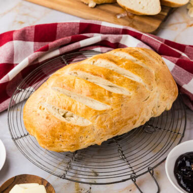 A loaf of One Hour Bread resting on a wire rack