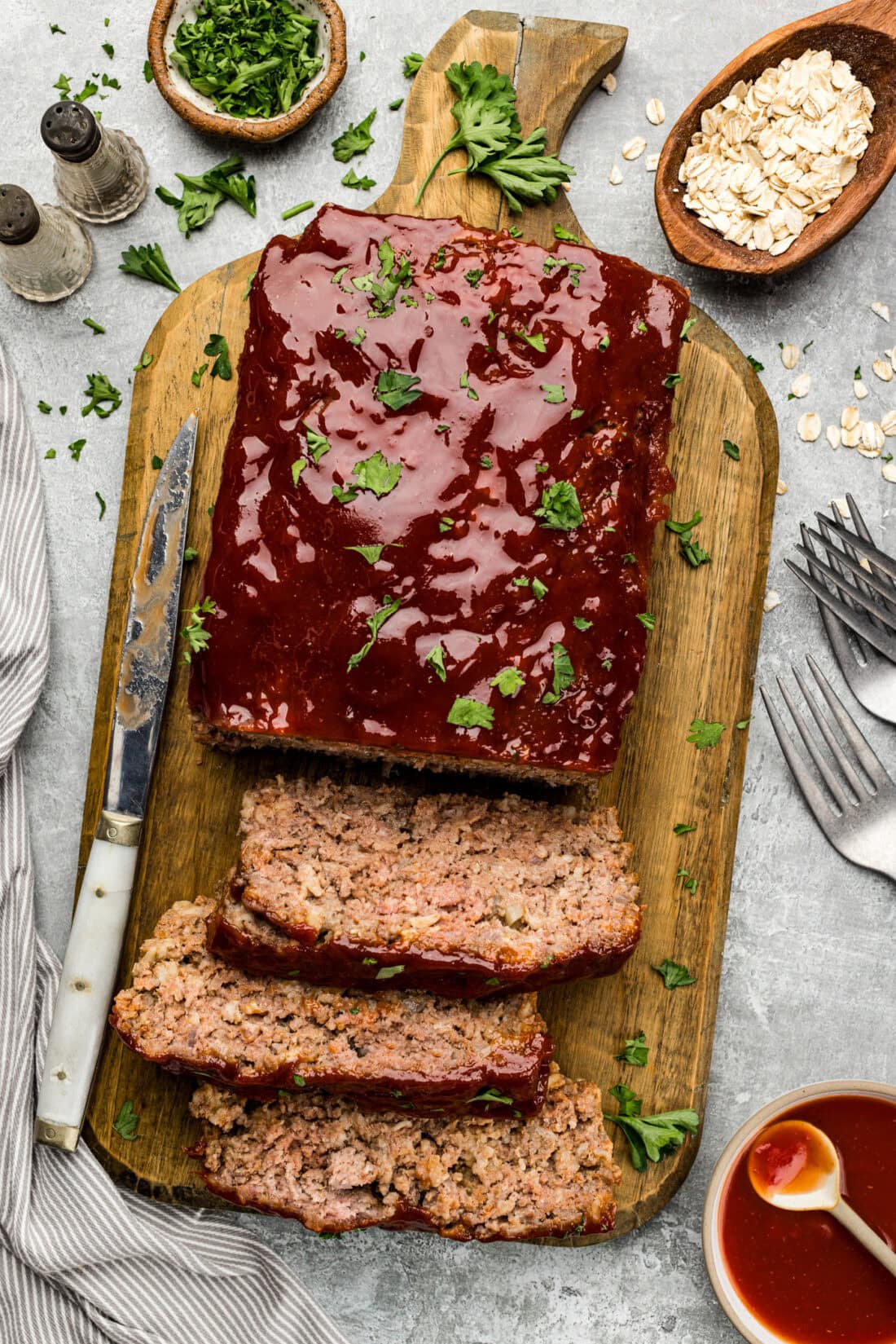 Quaker Oats Meatloaf cut into slices on a wooden cutting board