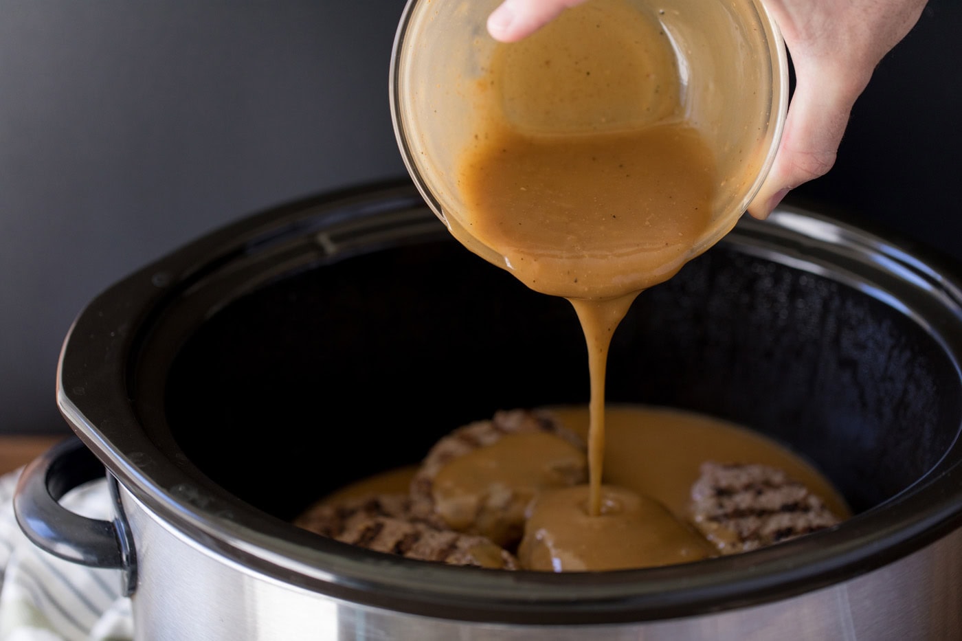 gravy poured over salisbury steak patties in a crockpot
