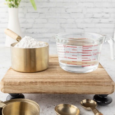 A glass measuring cup and a dry measuring cup sitting next to each other