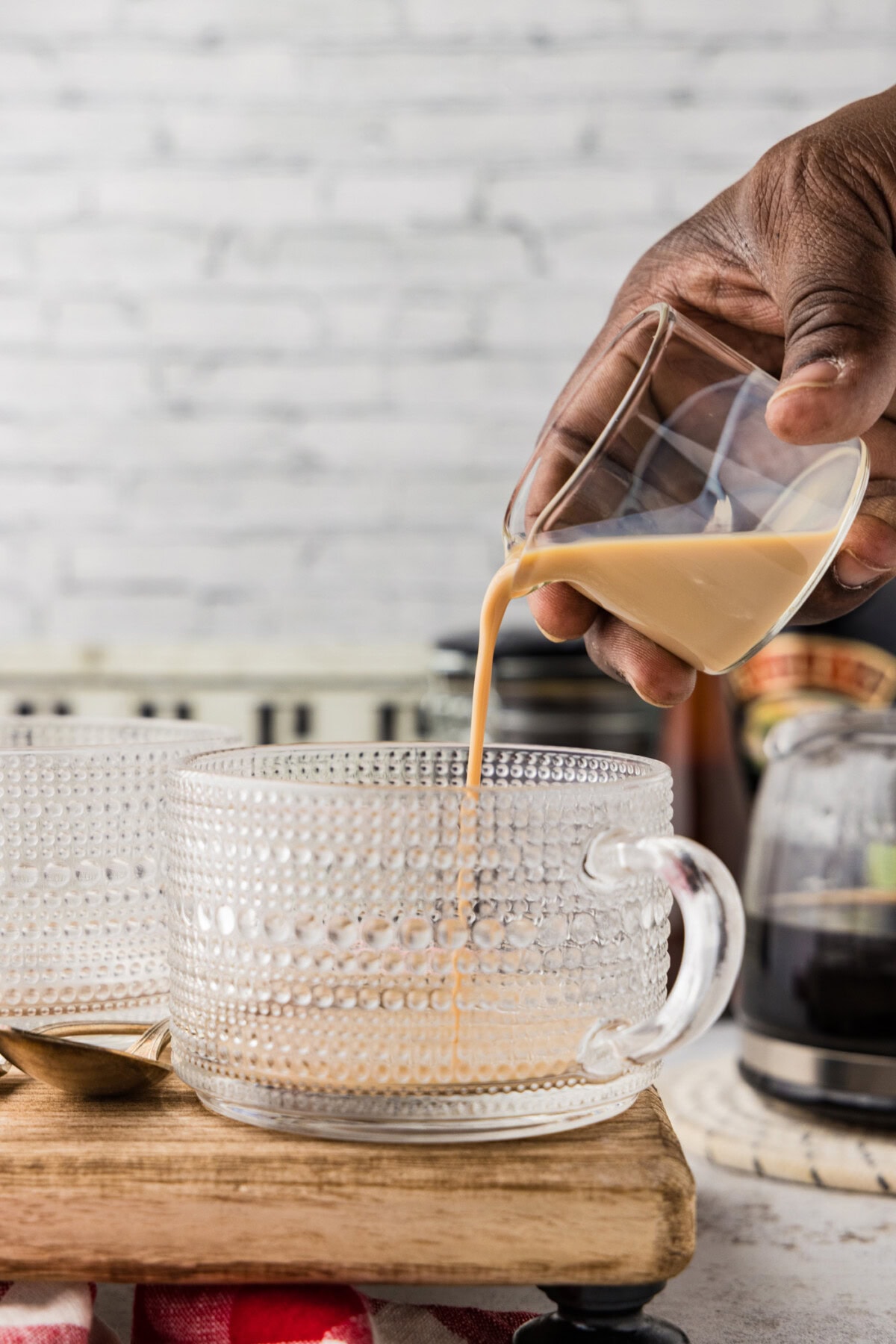 Pouring baileys into a glass coffee mug