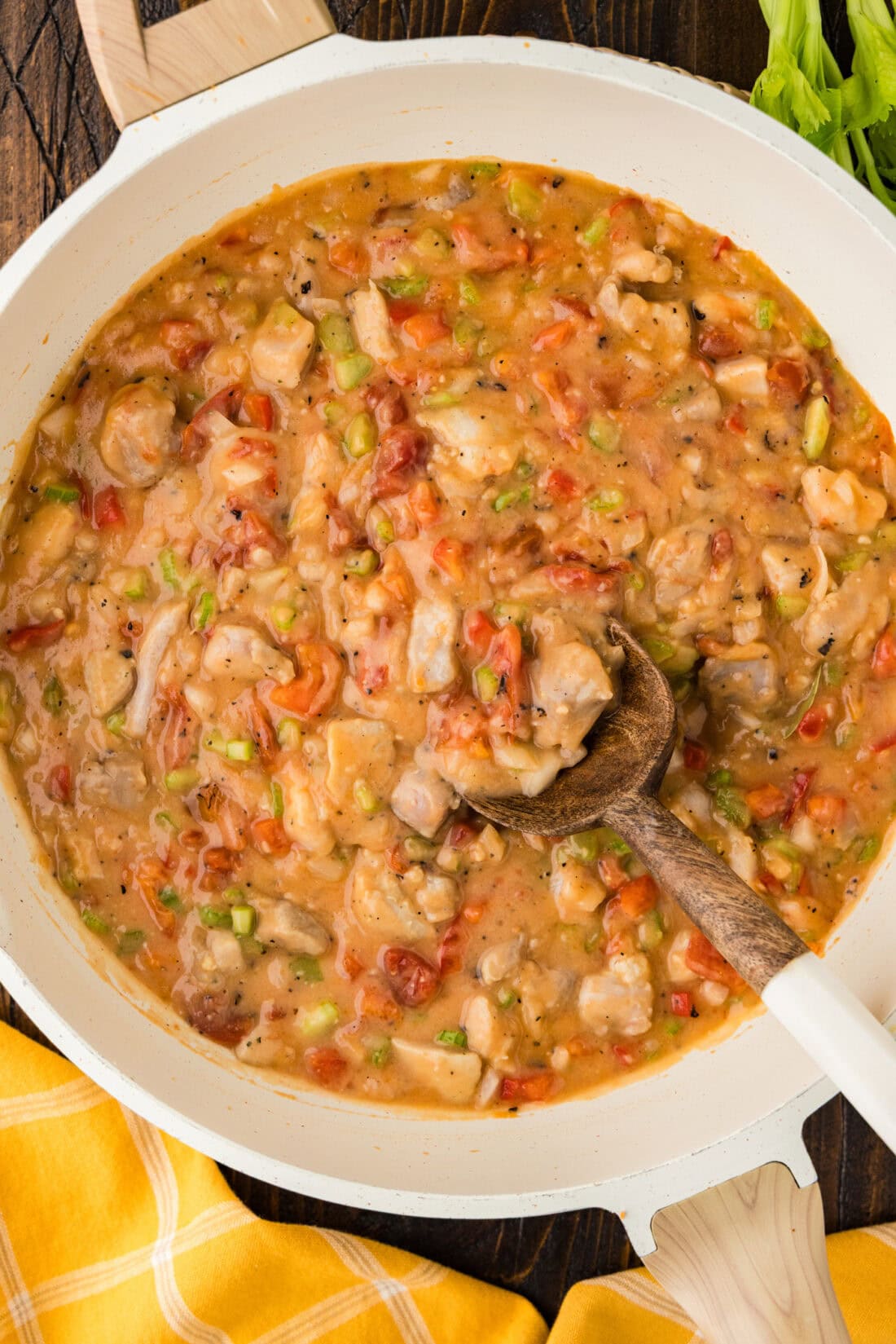 Skillet of Chicken Etouffee with a spoon in it