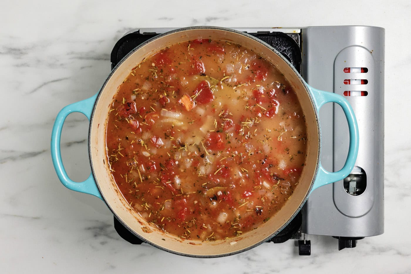 Chicken broth added to pot with tomato broth