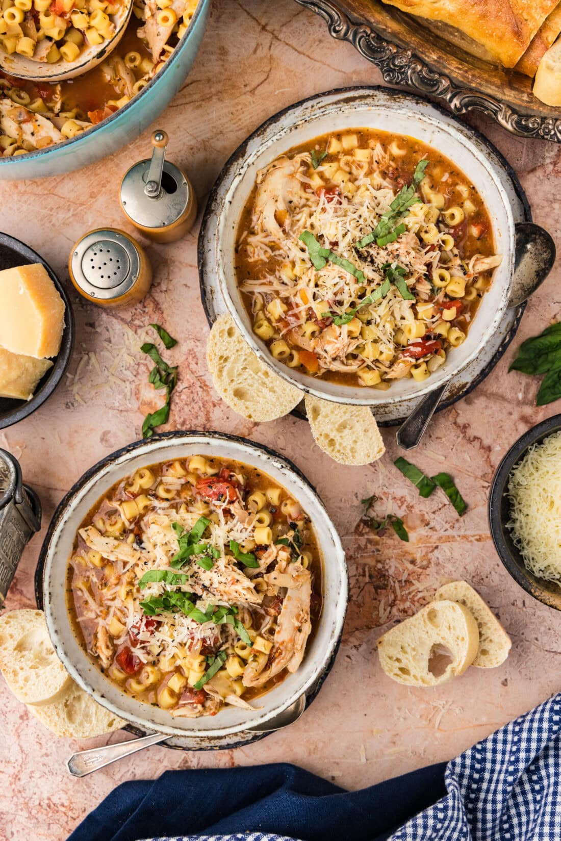 Two bowls of Chicken Parmesan Soup with crusty bread on the side