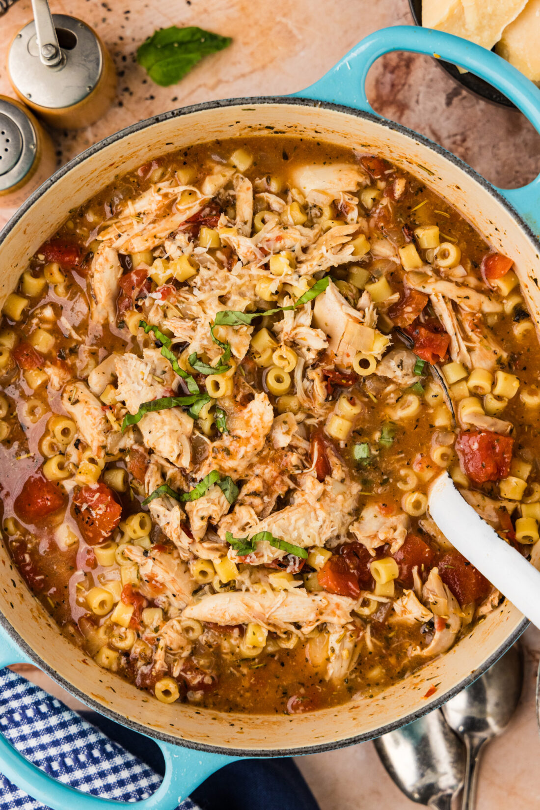 Close up photo of a spoon in a pot of Chicken Parmesan Soup