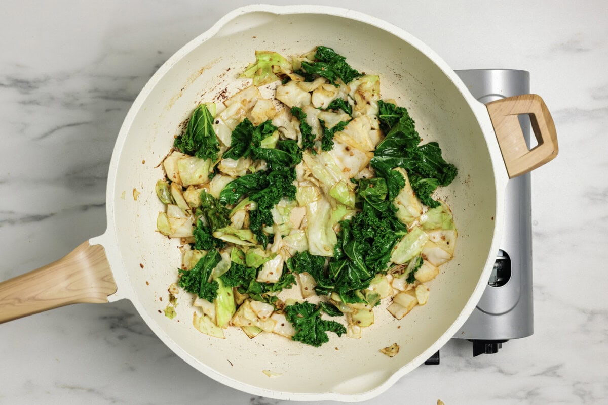 cabbage, kale, butter, and garlic in a saucepan