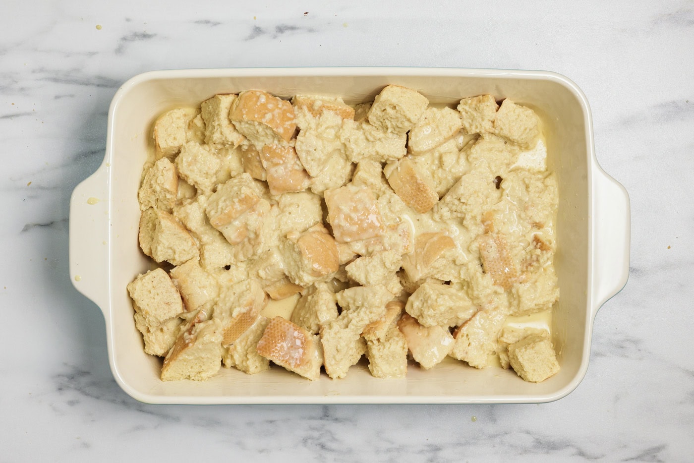 Soaked bread cubed in a baking dish