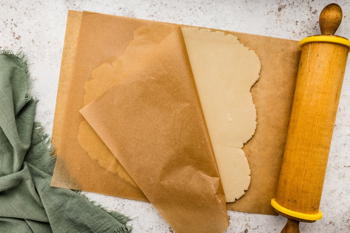 Peeling off parchment paper from rolled out shortbread cookie dough