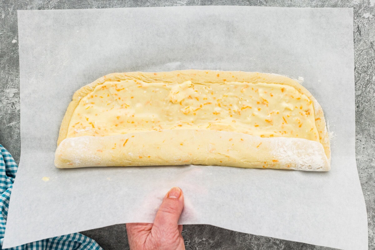 Rolling dough with filling up using parchment paper