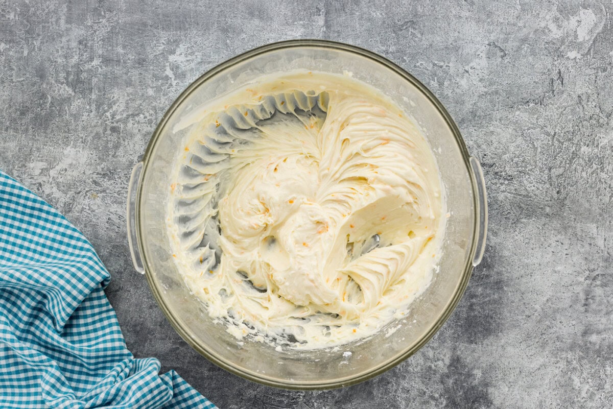 Orange cream cheese frosting in a mixing bowl