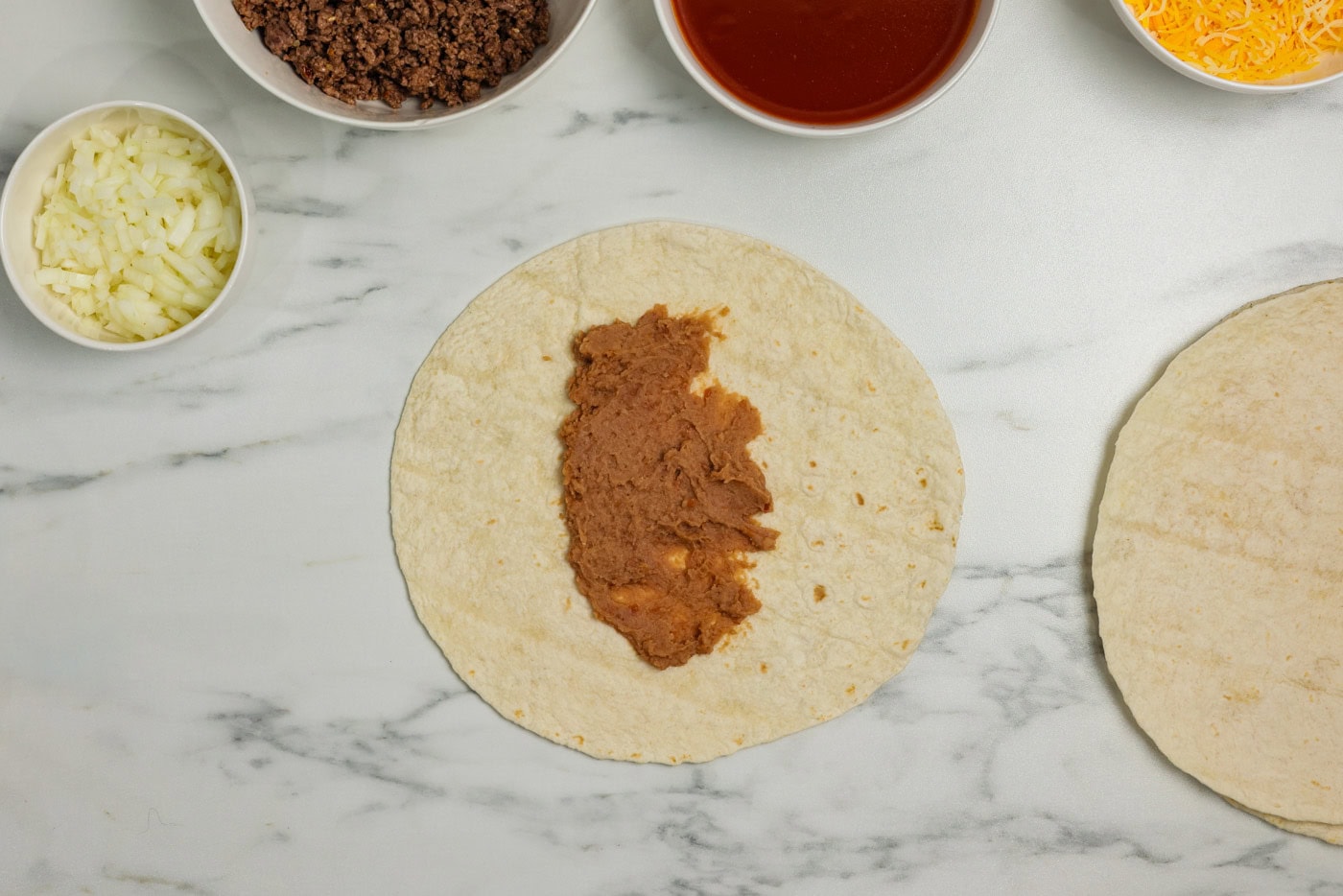 refried beans spread on a tortilla