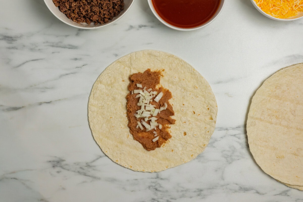 diced onion on top of refried beans