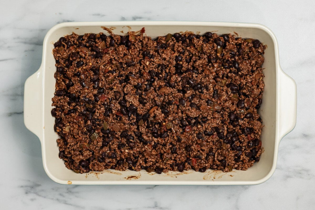 Ground beef mixture with beans added to a casserole dish