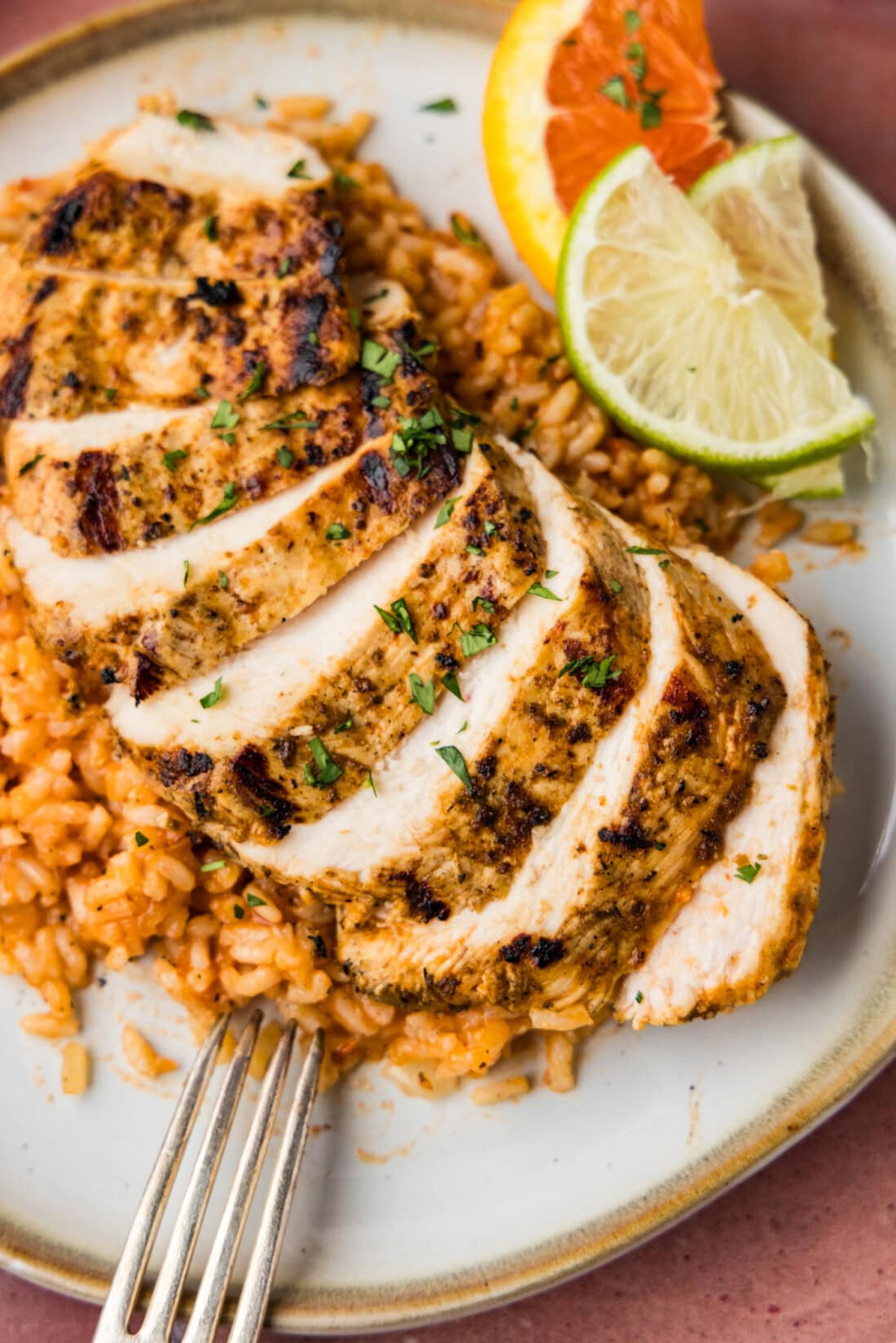 sliced Baja Chicken over Mexican rice on plate with fork