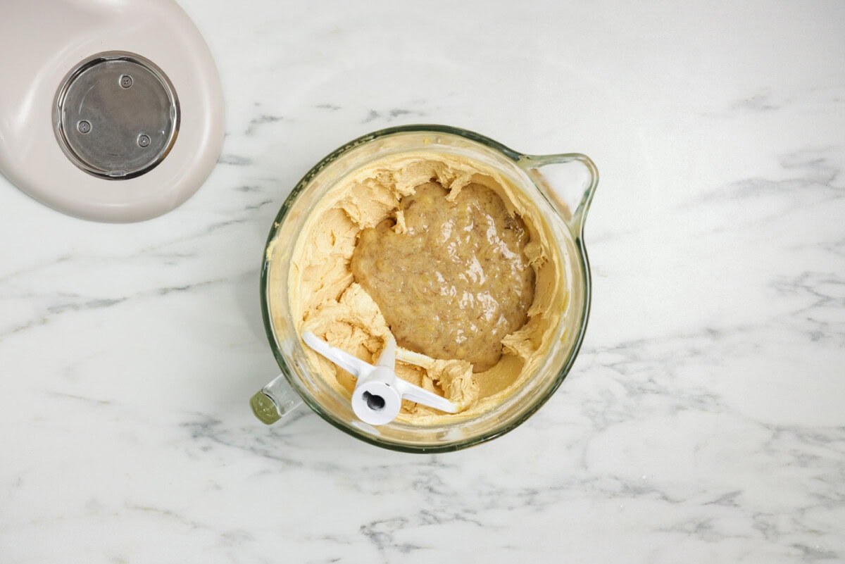 mashed bananas in a bowl with cake batter