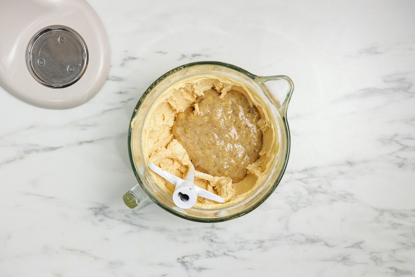 mashed bananas in a bowl with cake batter