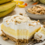 slice of Banana Cream Lush with a bite removed and bananas in the background