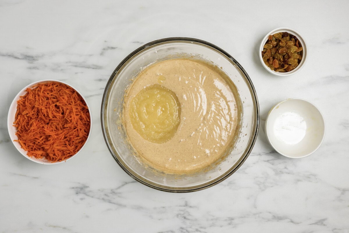 applesauce added to spice cake batter in a bowl