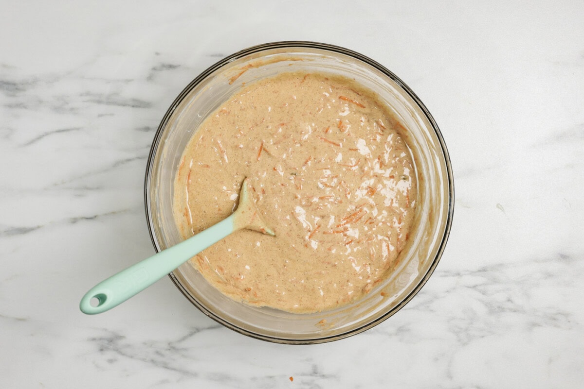 carrot cupcake batter in a bowl with a rubber spatula