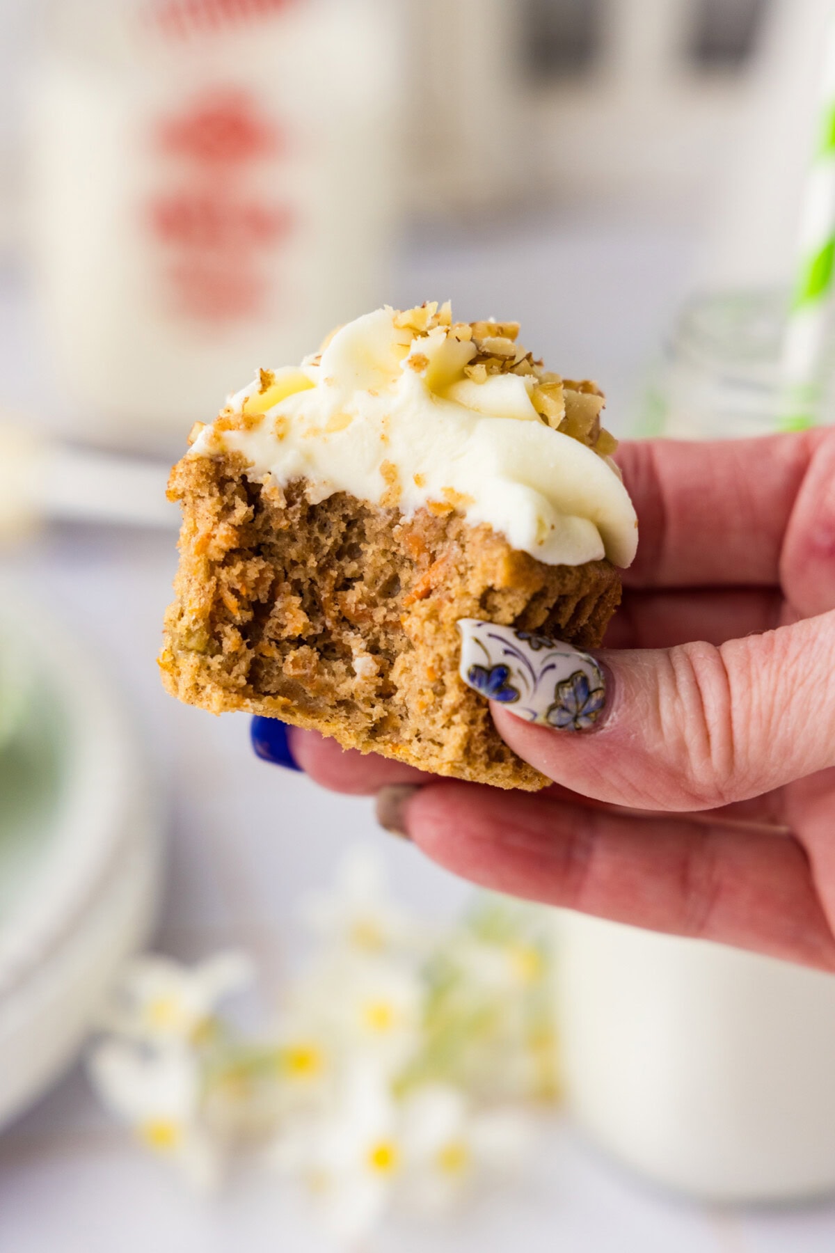Hand holding a Carrot Cupcake with a bite taken out