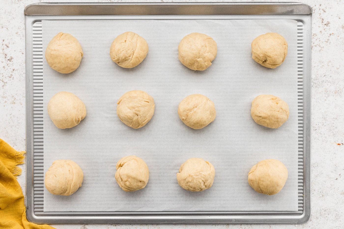 Concha dough balls on a parchment lined baking sheet