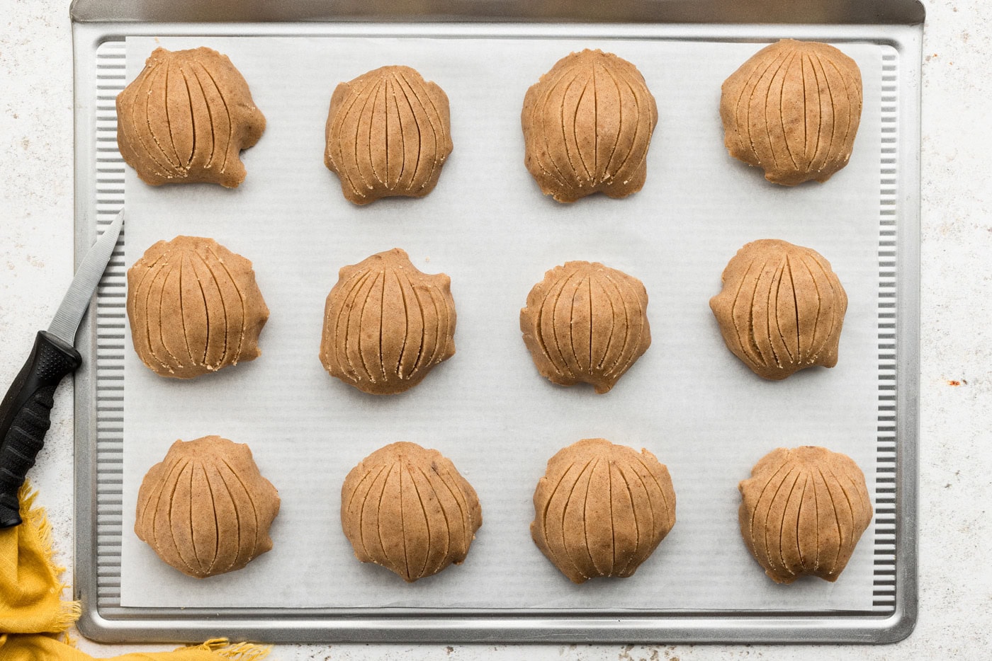 Unbaked conchas on a baking sheet with sugar topping
