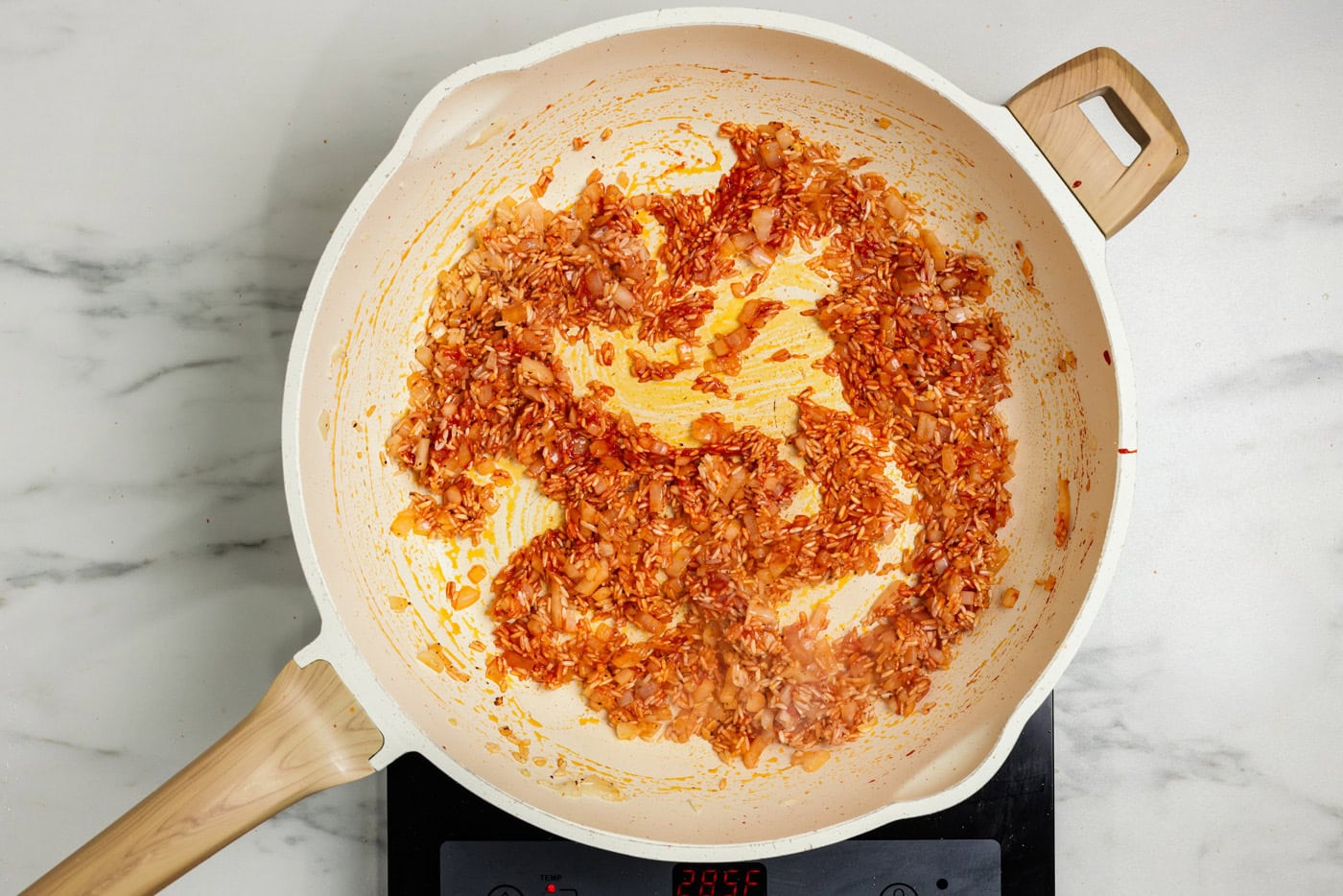 tomato paste stirred into rice in skillet