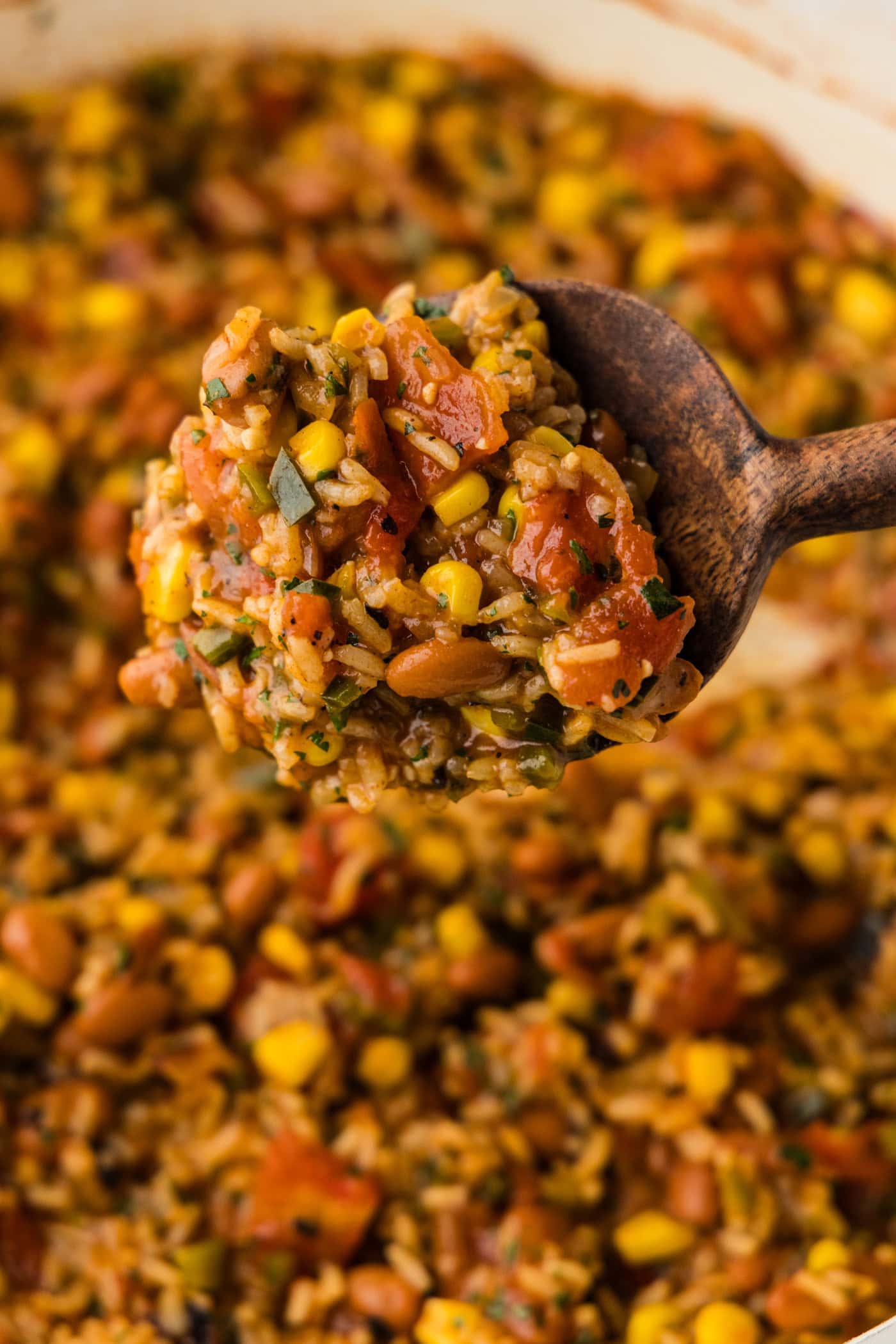 wooden spoon of Mexican Rice and Beans over skillet