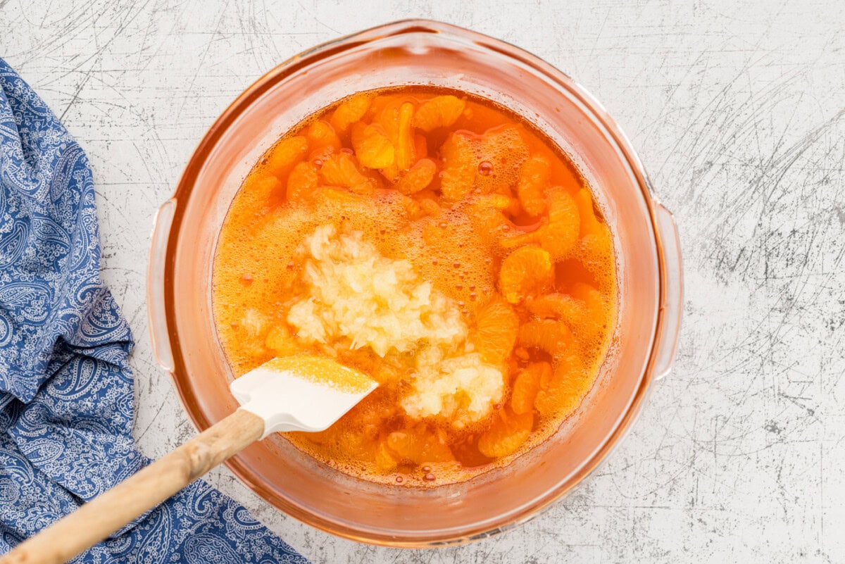 mandarin oranges added to jello in bowl