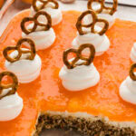 pan of Orange Pretzel Salad garnished with whipped cream and pretzels