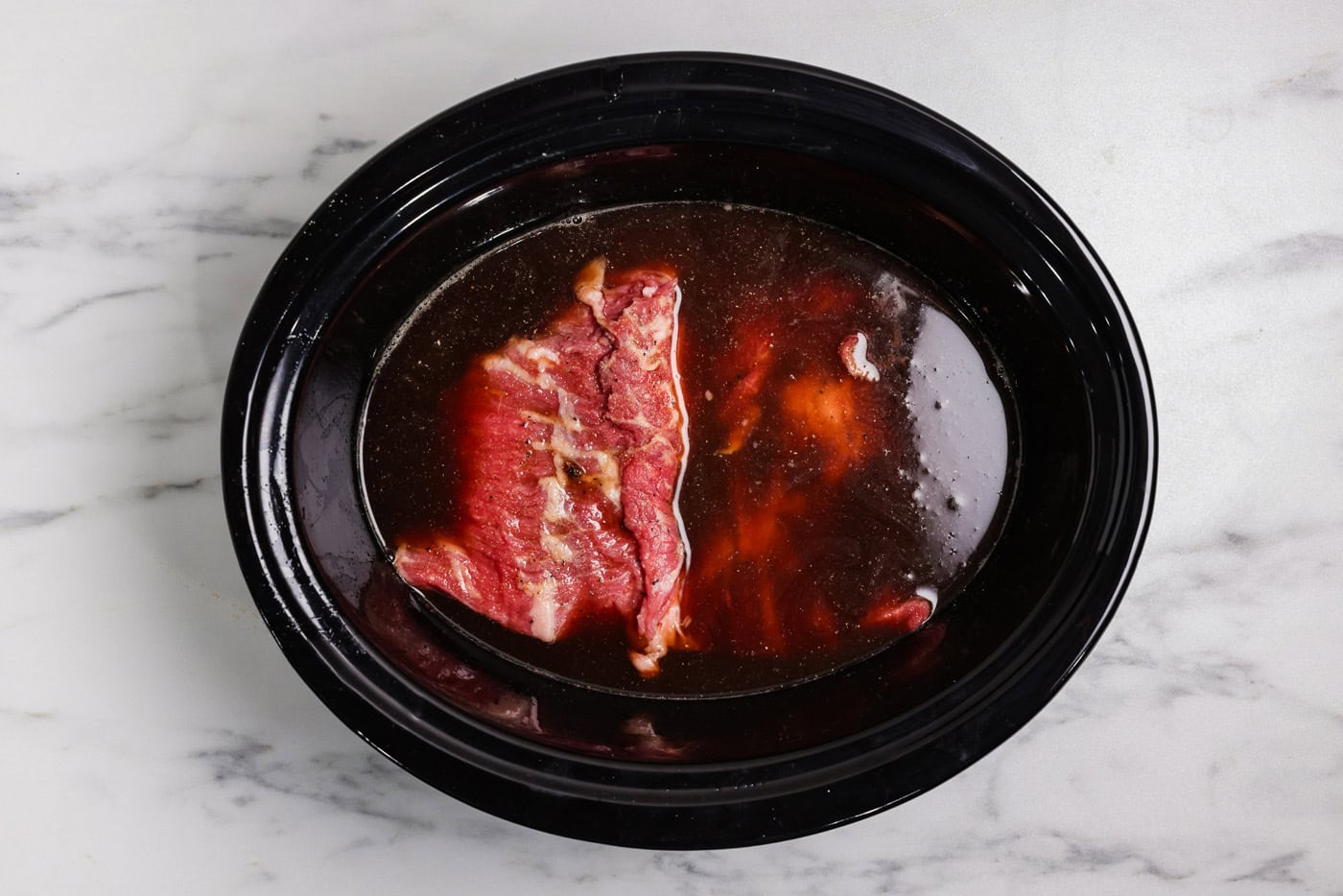 brisket and liquid ingredients in slow cooker