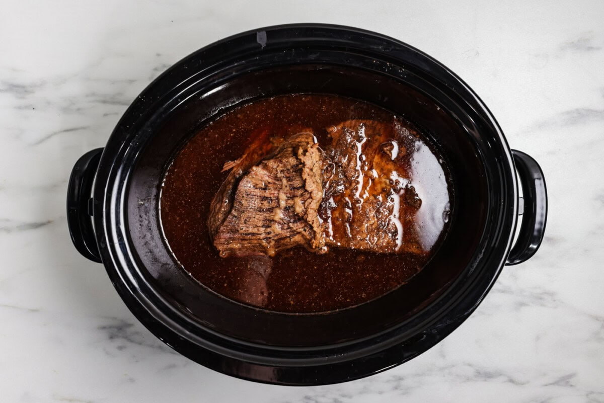 brisket in crock of slow cooker after being cooked